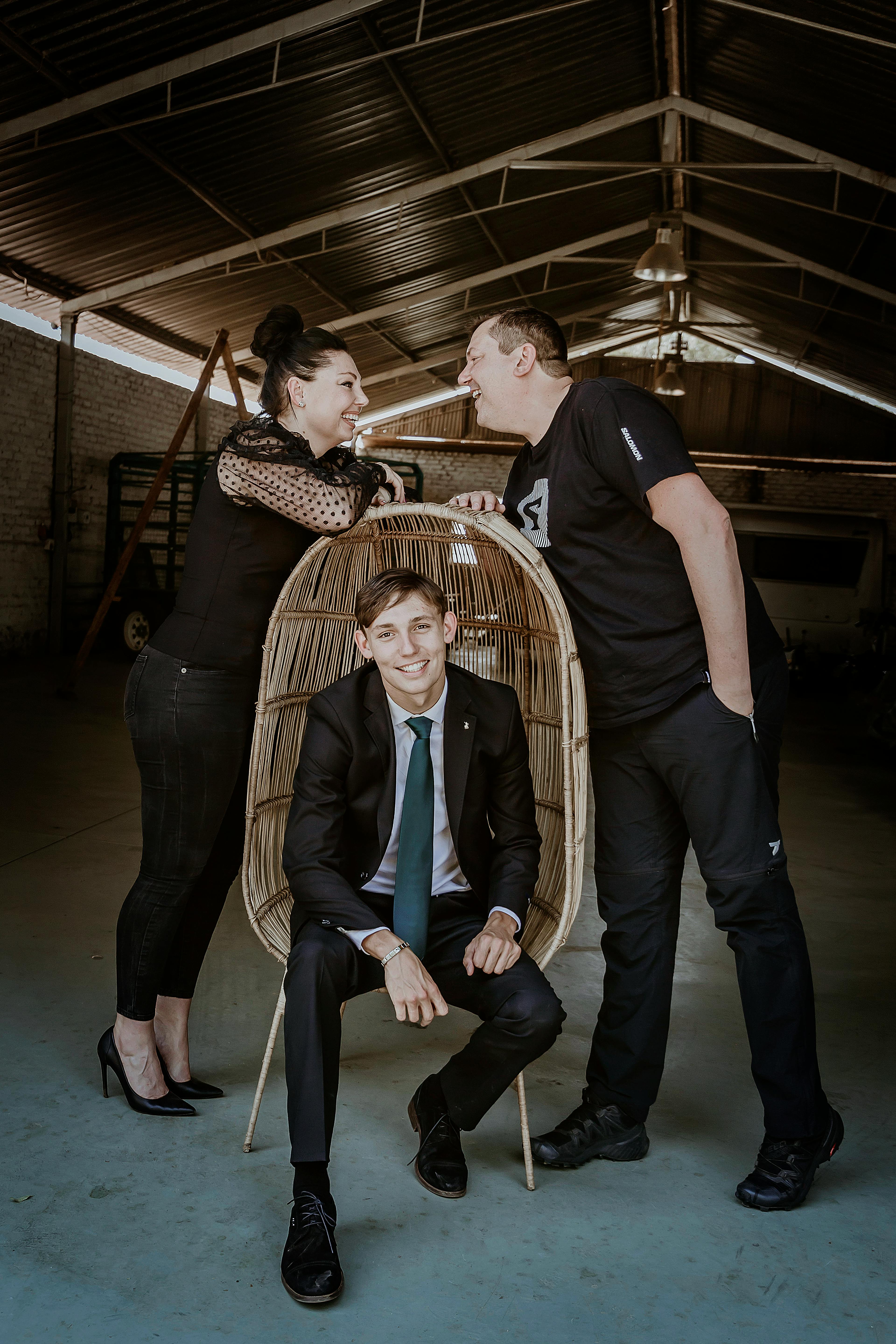 Family portrait in a rustic barn in Pretoria, showcasing stylish attire and joyful interaction.