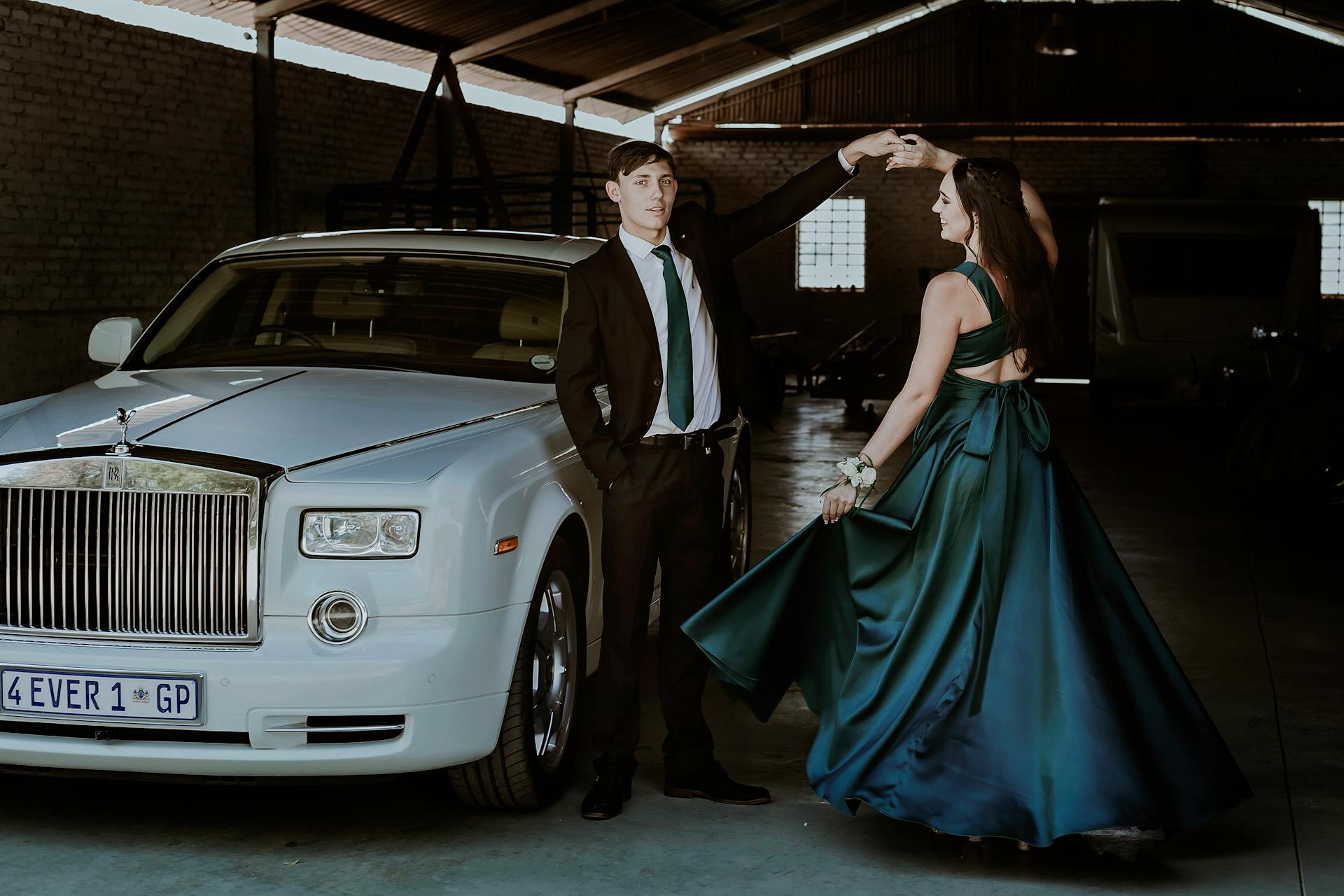 Elegant Man and Woman Posing by a White Rolls-Royce Phantom Car