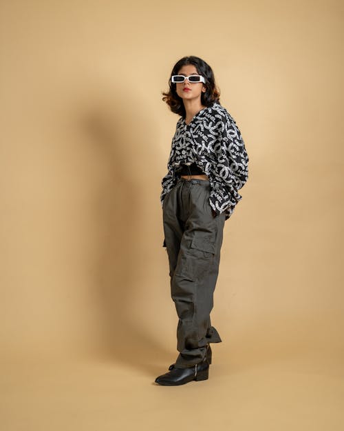Young model in a patterned crop top and gray cargo pants