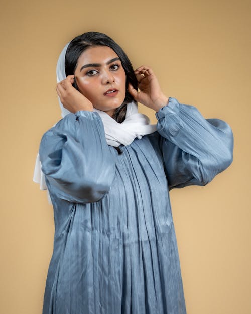 Model in a Loose Blue Dress and a White Headscarf