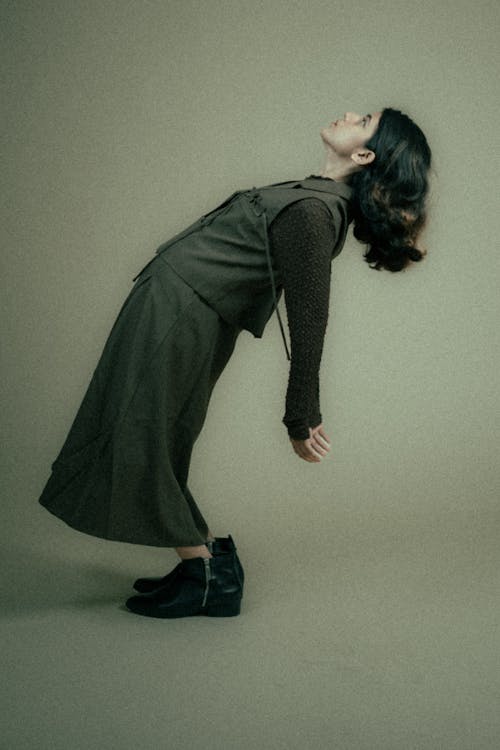 Young Model in a Gray Vest and Skirt Model Bending Backwards