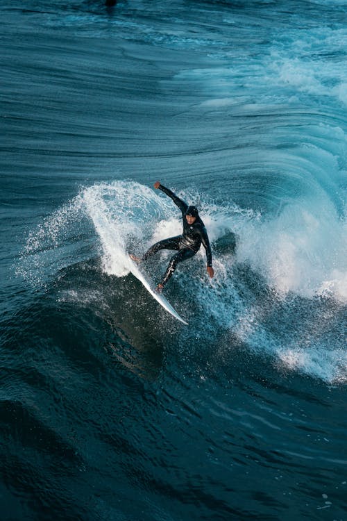 Man in a Wetsuit Surfing on a Wave