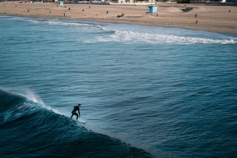 Hombre surfeando una ola cerca de la orilla