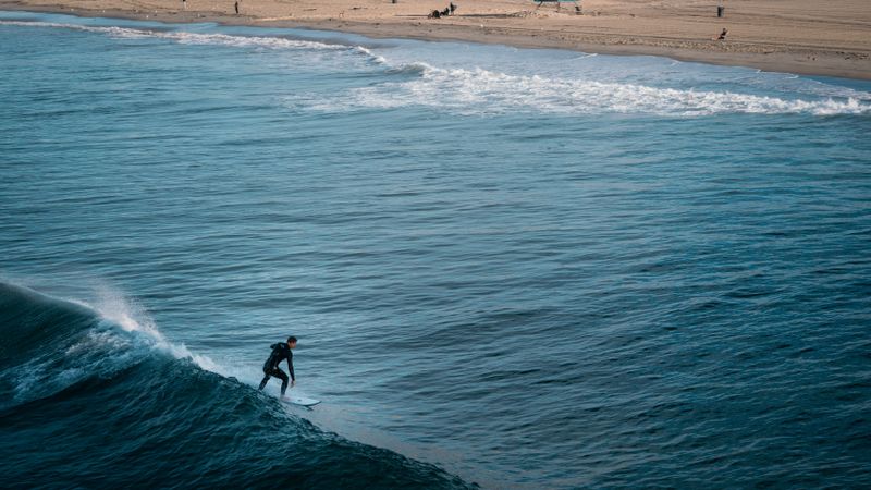 Hombre surfeando una ola cerca de la orilla
