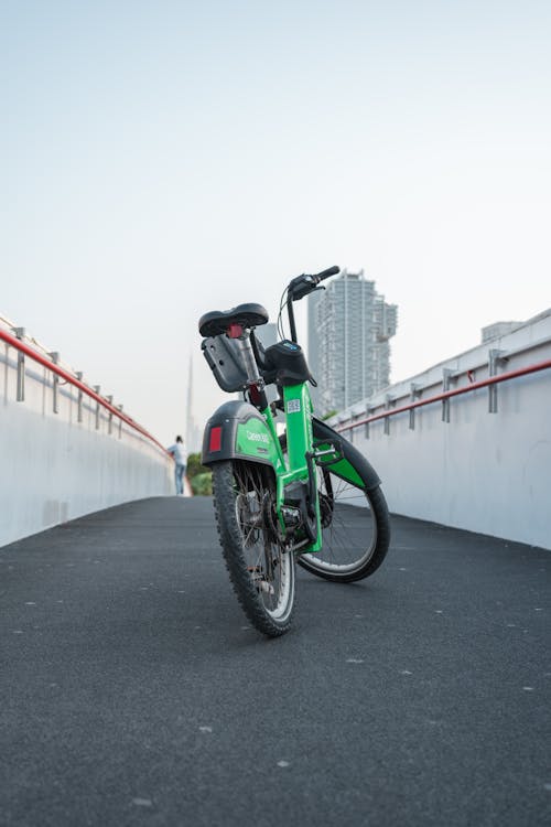 A green motorcycle parked on a bridge