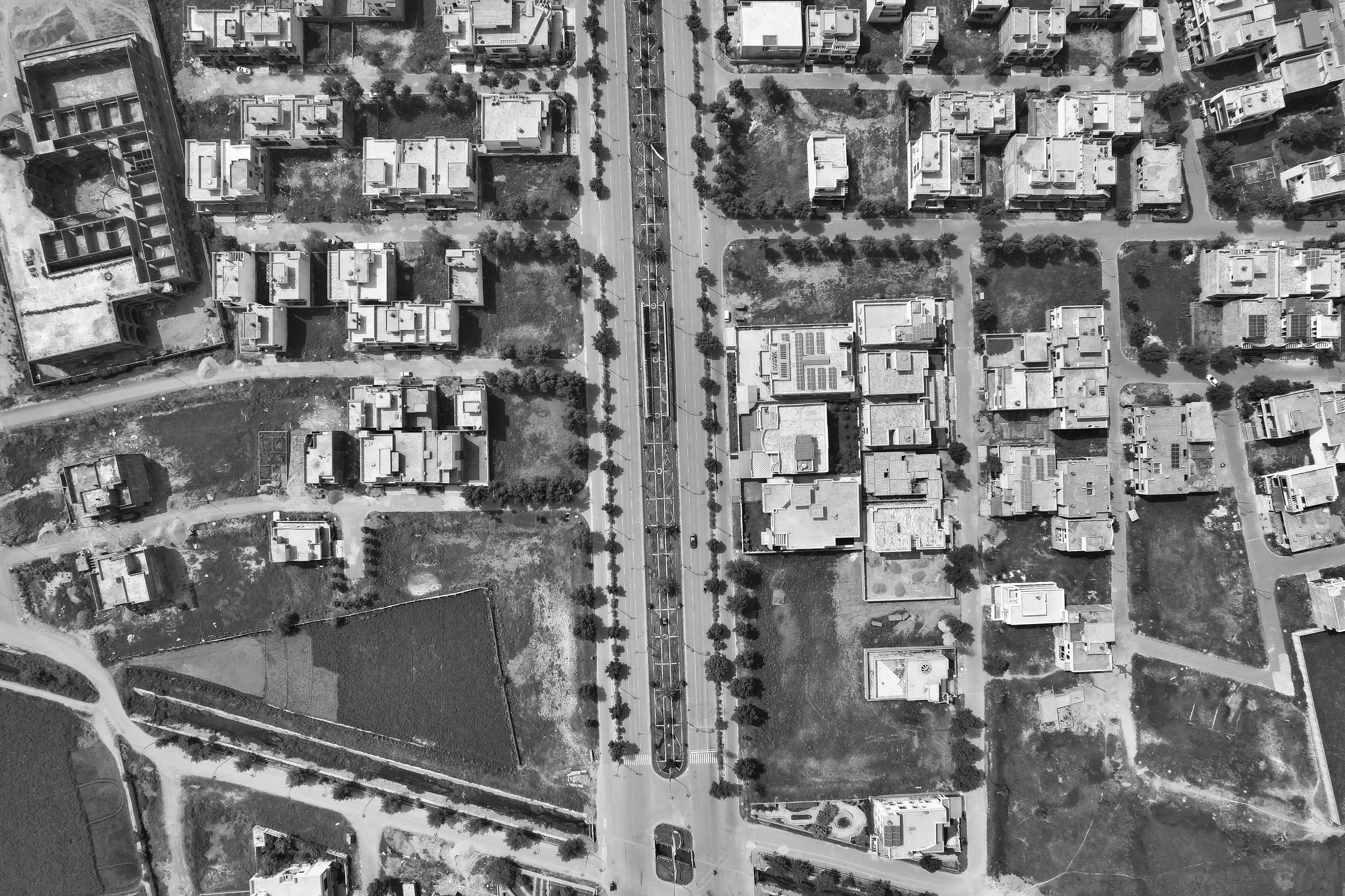 roofs of buildings and streets in town in black and white