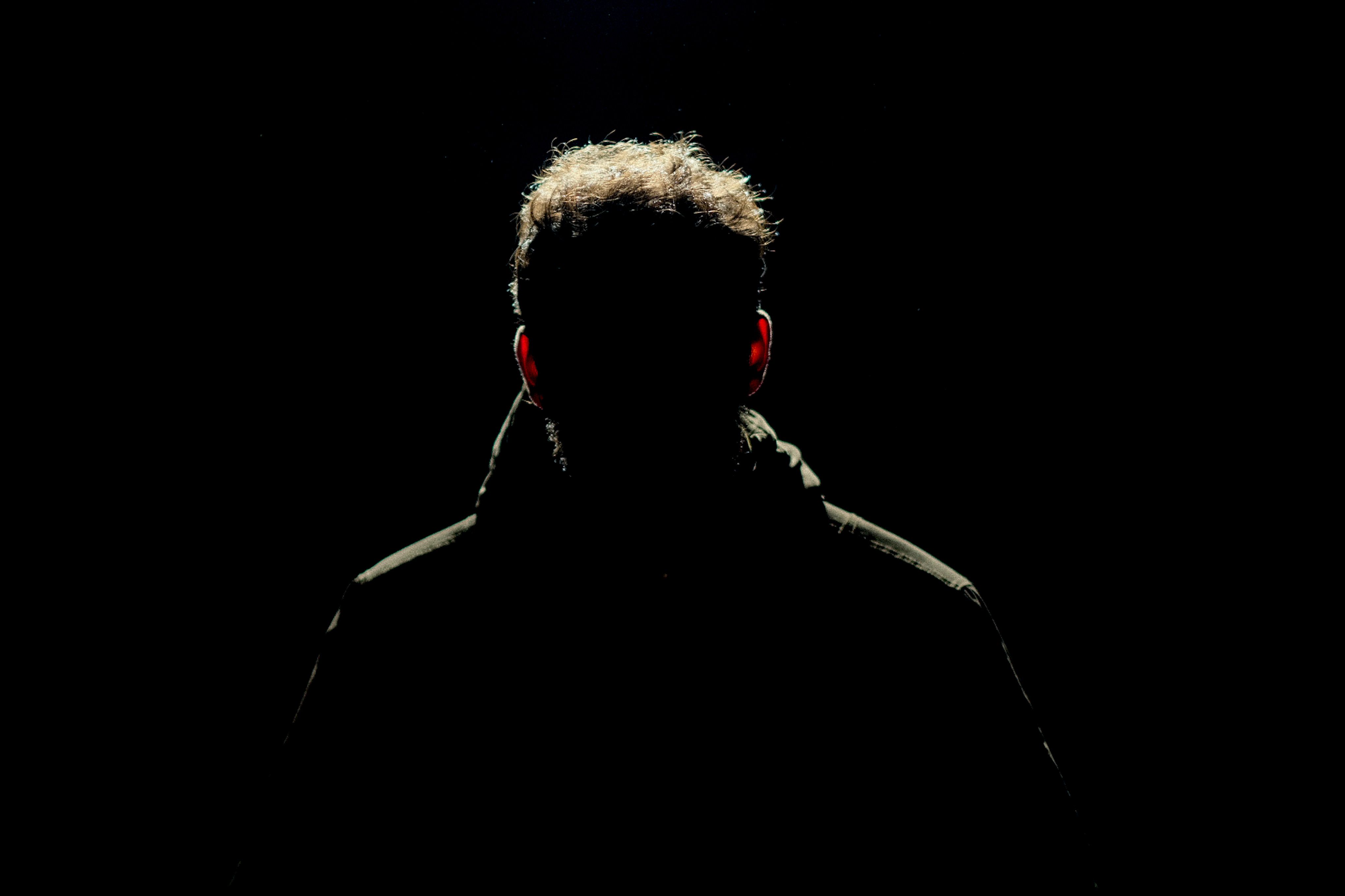 Silhouette of a man isolated in darkness, creating a mysterious ambiance.