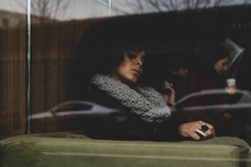 Woman Sitting Inside Building Near Glass Wall