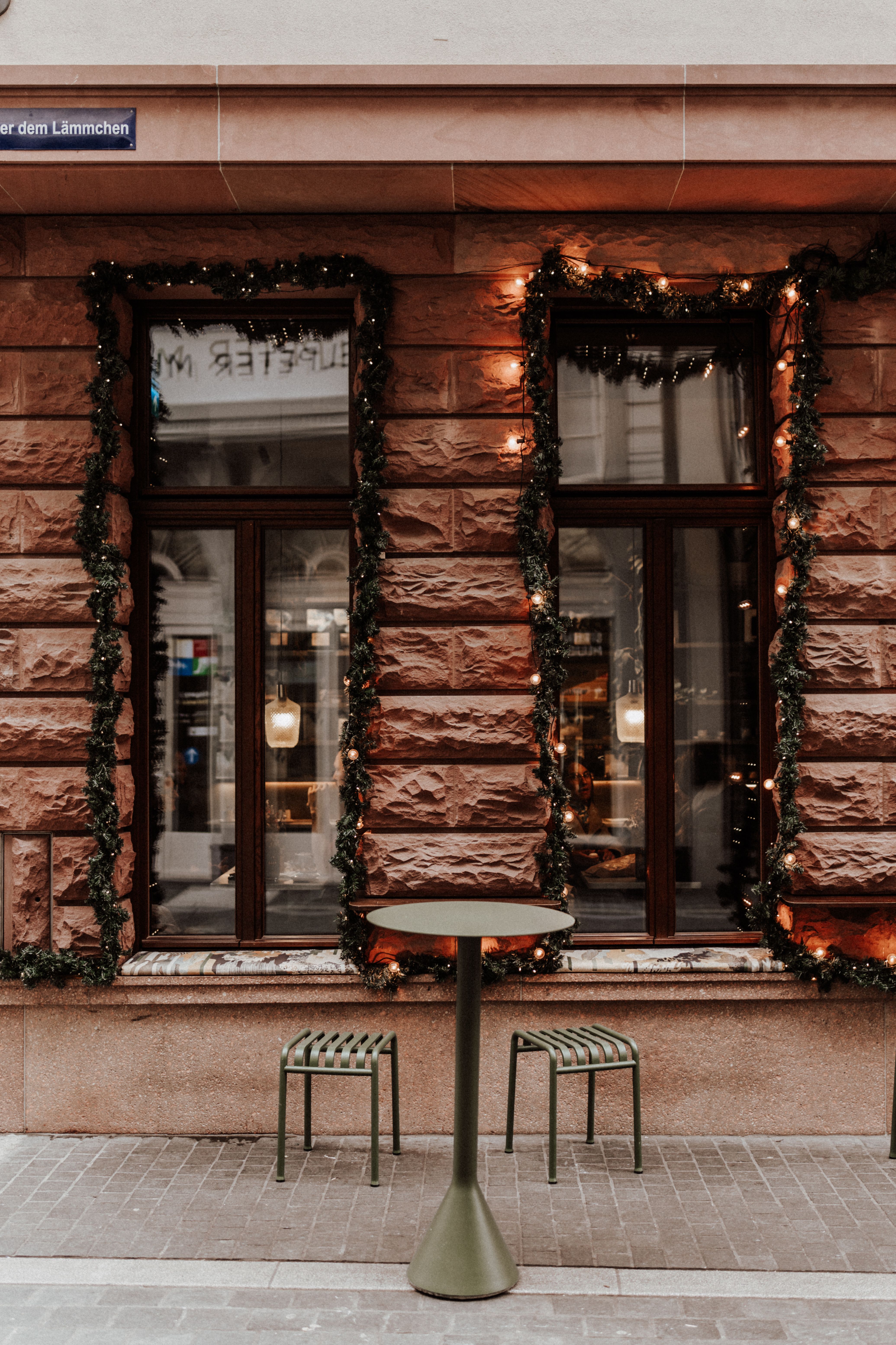 A festive city street view with decorated building facade and chairs.
