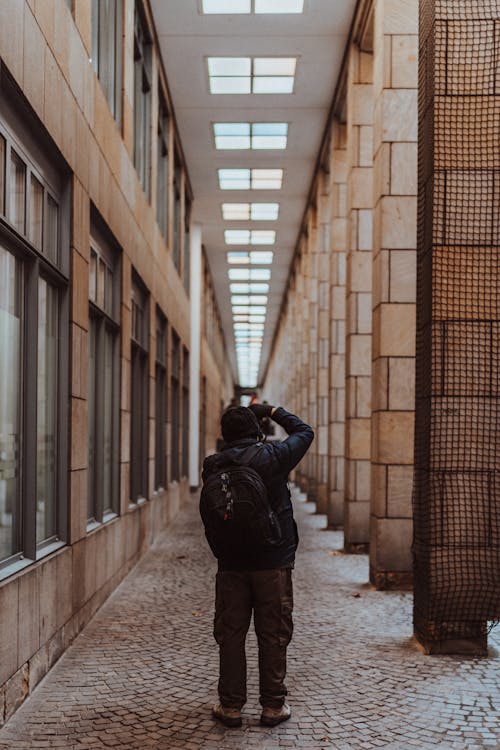 Free Photographer with Backpack Taking Photo of Pillars Stock Photo