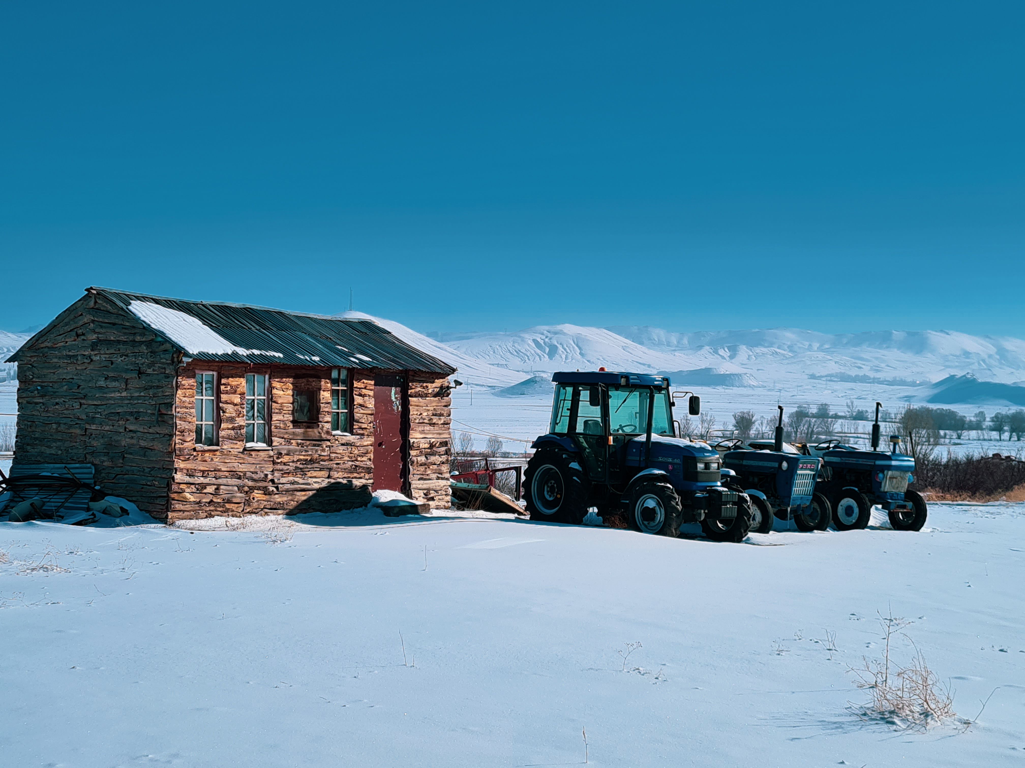 Tractors Parked near a House in the Countryside Covered with Snow ...