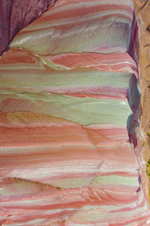 Free Aerial view of colorful layered sandstone in a canyon showcasing vivid geological patterns. Stock Photo