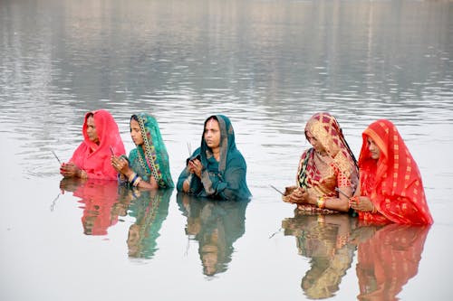 Women in Sarees Standing in the River and Praying 