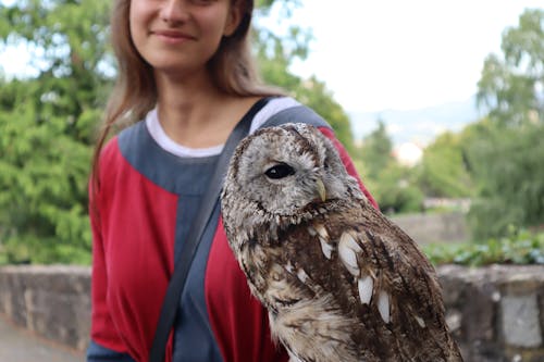 A Woman Standing next to an Owl 