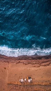 Stunning aerial shot of İzmir coastline with crashing waves, sand, and ocean beauty.