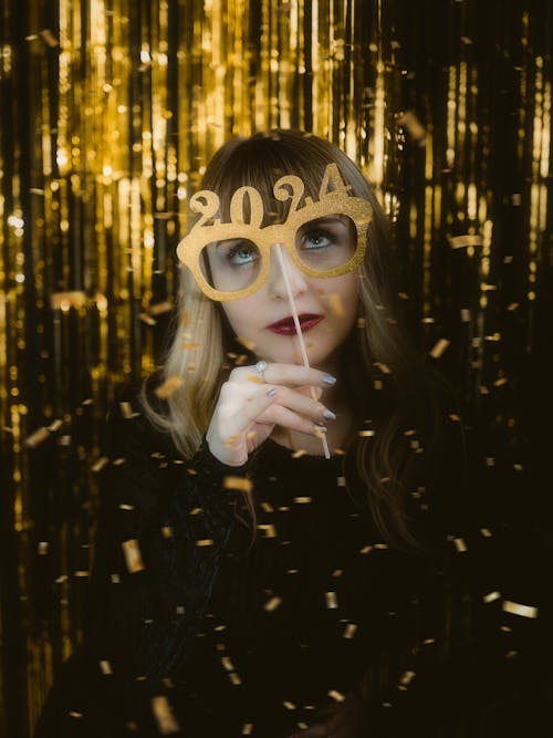 New Years Eve Guest With a Mask of Golden Glasses With the Year 2024 on the Handle