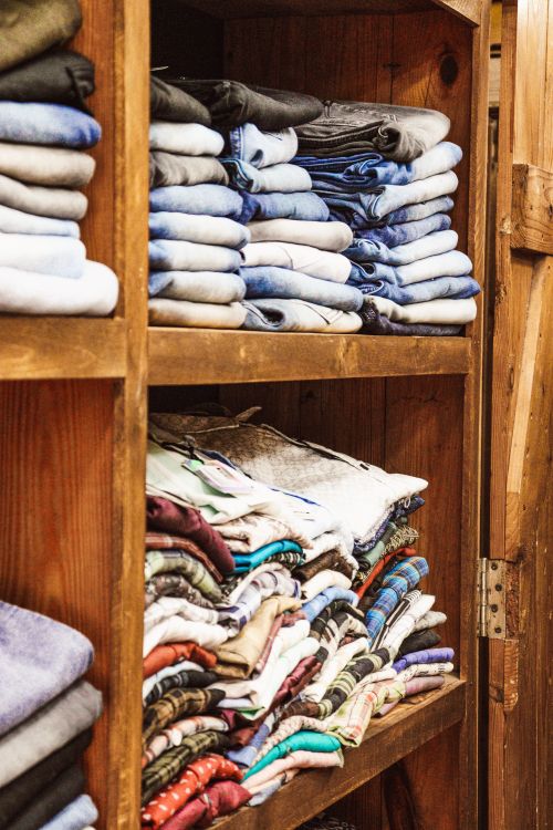 Neatly folded clothes stacked on open closet shelves