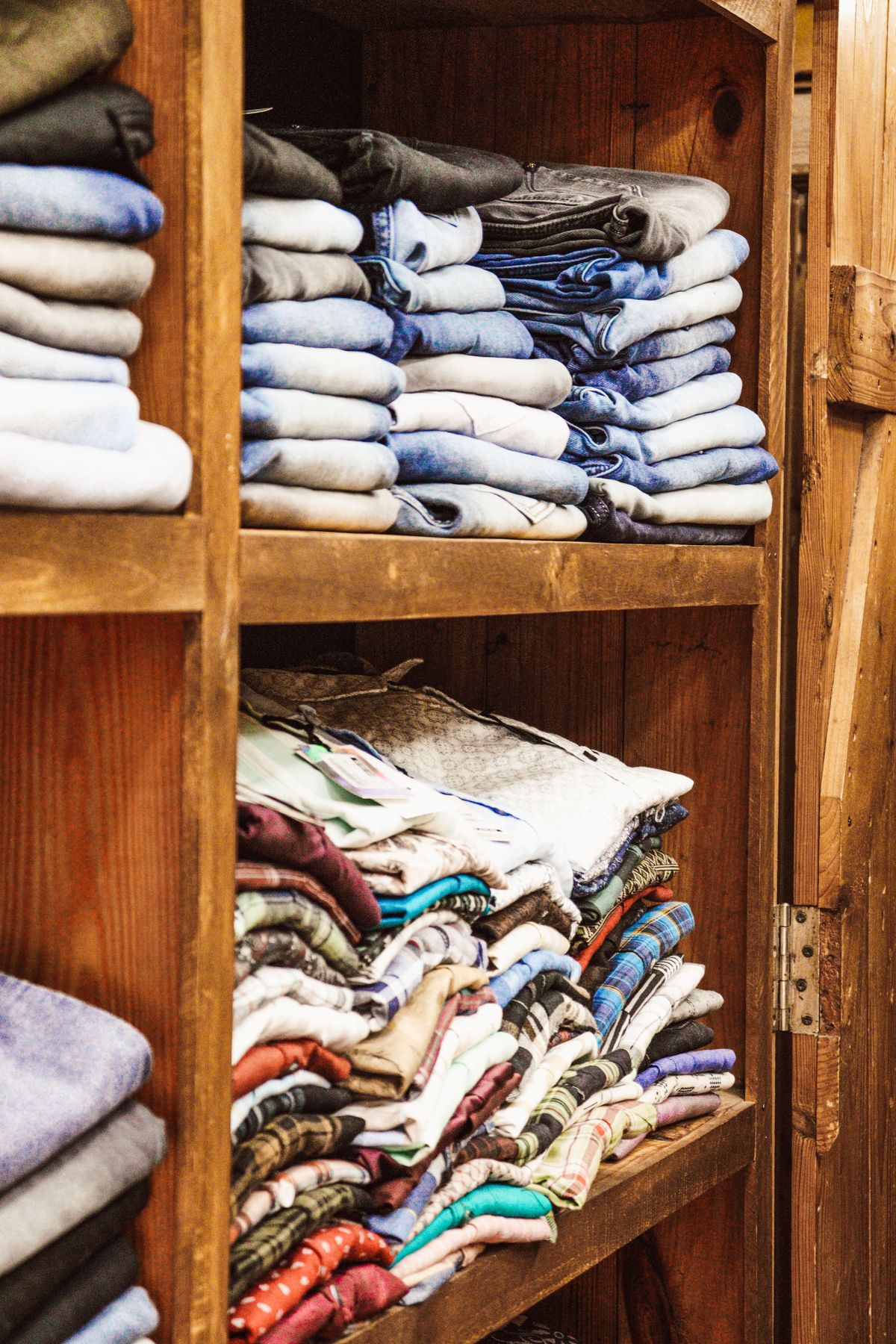 Neatly folded clothes on wooden shelves showing organization