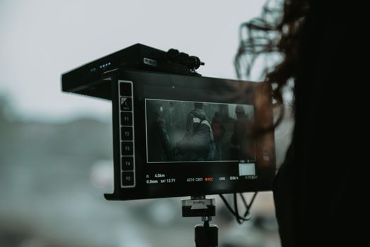 A close-up of professional filming equipment capturing a scene outdoors.