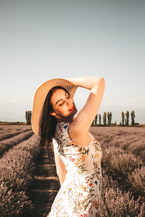 Woman in Dress and Hat Posing in Field