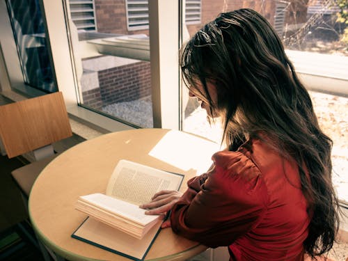 College girl sitting in library reading 