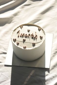 A simple, elegant 1-month celebration cake with chocolate decorations on a white background.