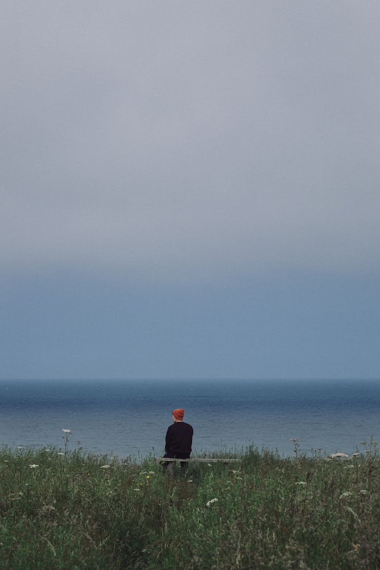 Man Sitting On Bench In Seaside