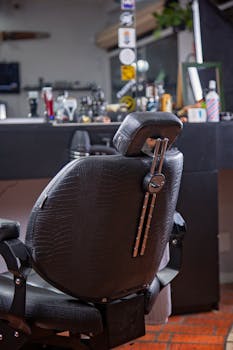 Luxurious barber chair with sleek design in a modern barbershop setting, showcasing professional grooming tools.