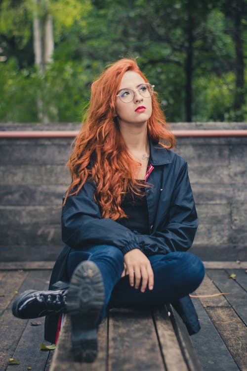 Free  Woman Sitting On Table Wearing Black Jacket Stock Photo