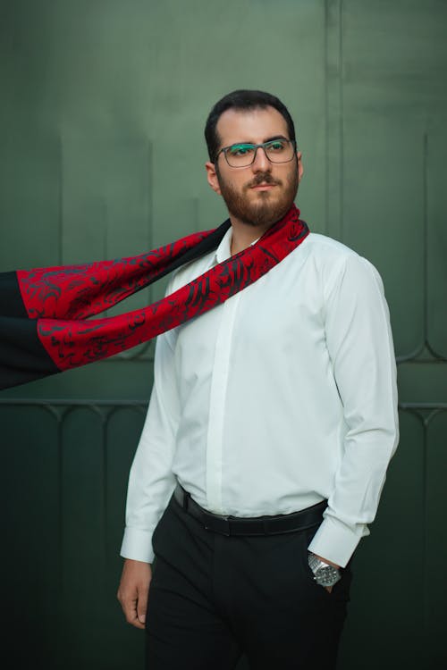 Elegant Man in a White Shirt and a Red Scarf Standing Outside 