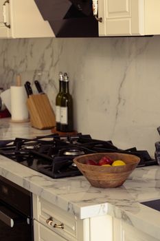 Marble kitchen counter with fruit bowl and stylish appliances.