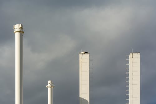 Industrial Chimneys Against Cloudy Sky