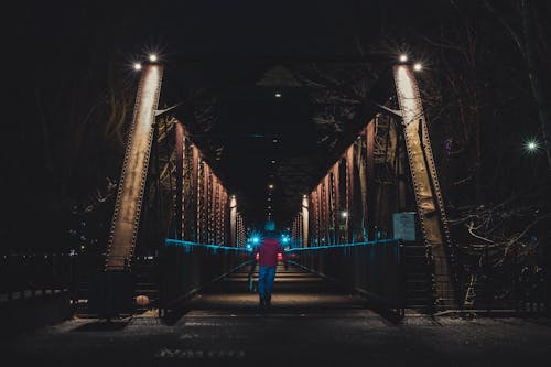 야간 동안 다리에 걷는 사람