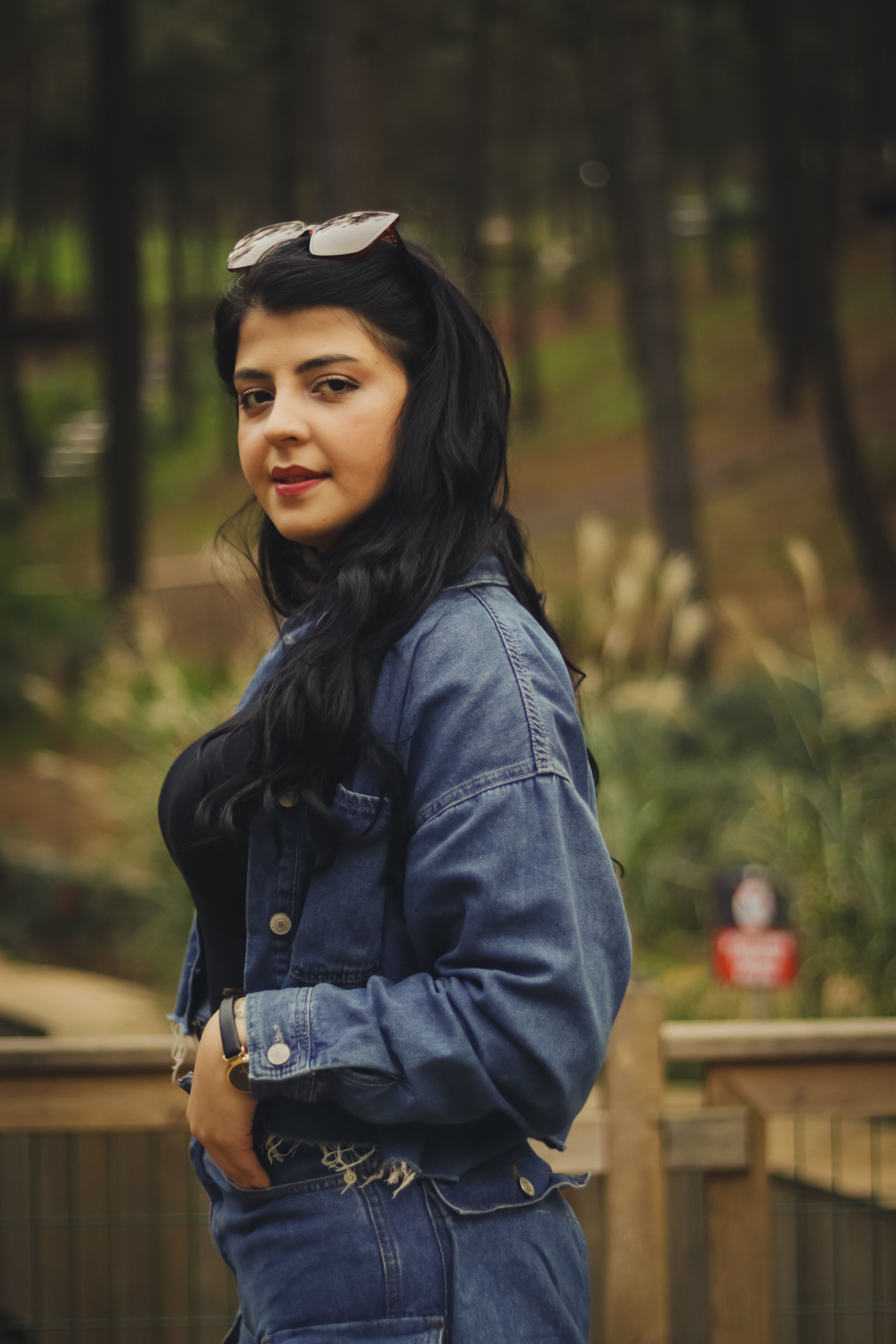 Woman in a denim jacket with sunglasses, a cool casual airport outfit idea