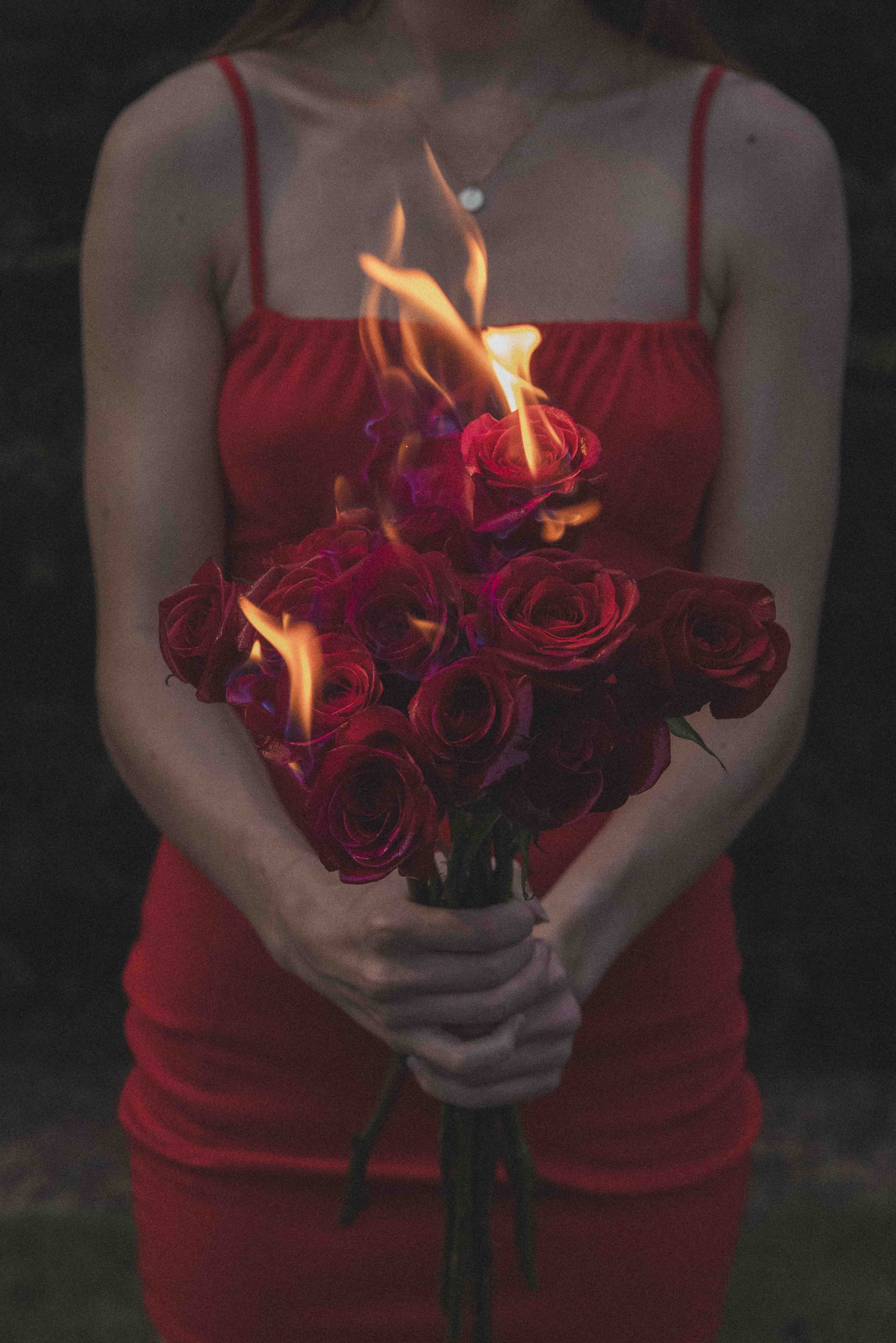 Woman in a Red Dress Holding a Bouquet of Burning Roses · Free Stock Photo