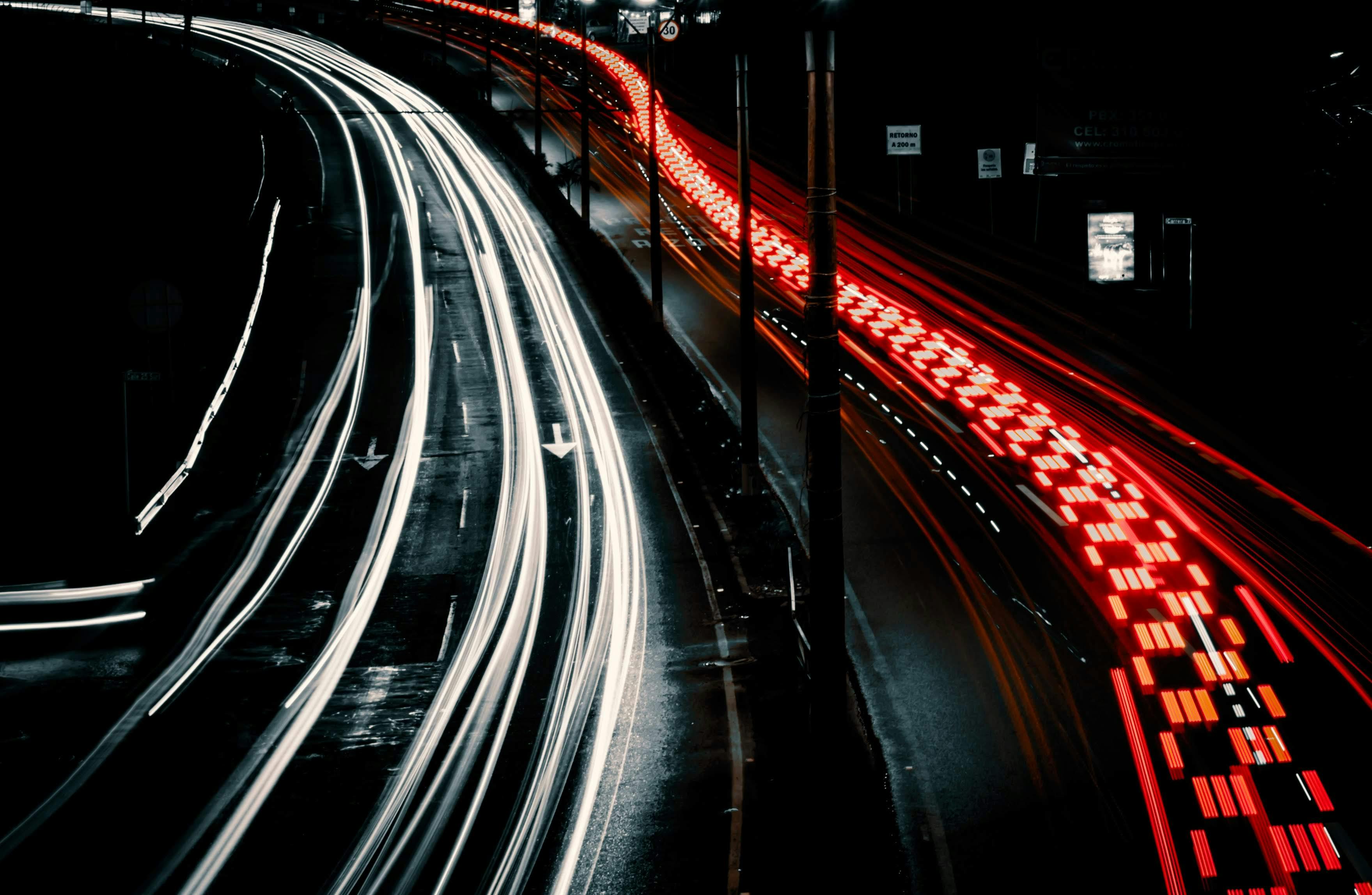 Dynamic long exposure photo capturing vibrant light trails on a city highway at night, highlighting urban movement.