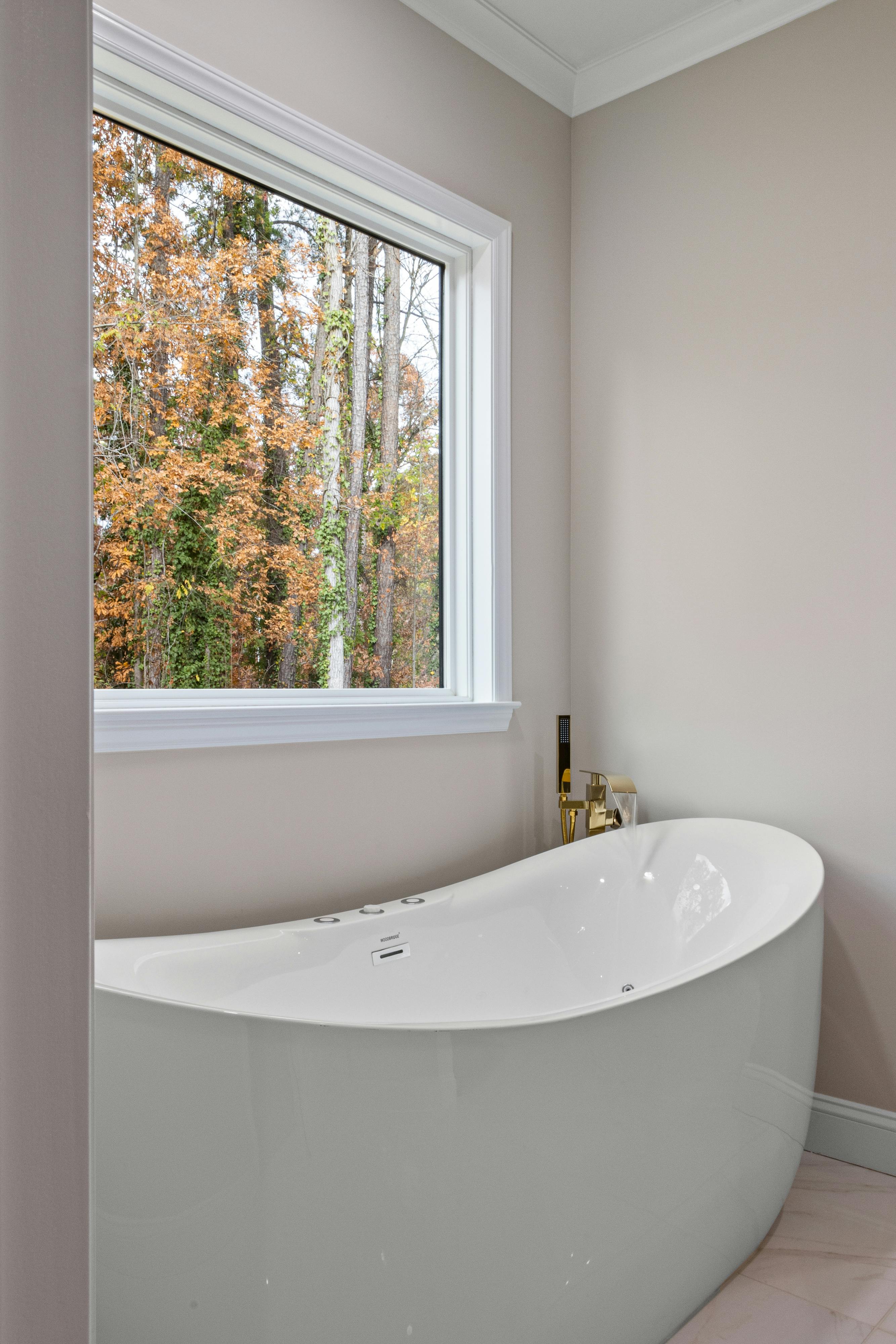 Freestanding tub positioned by a large window with natural light