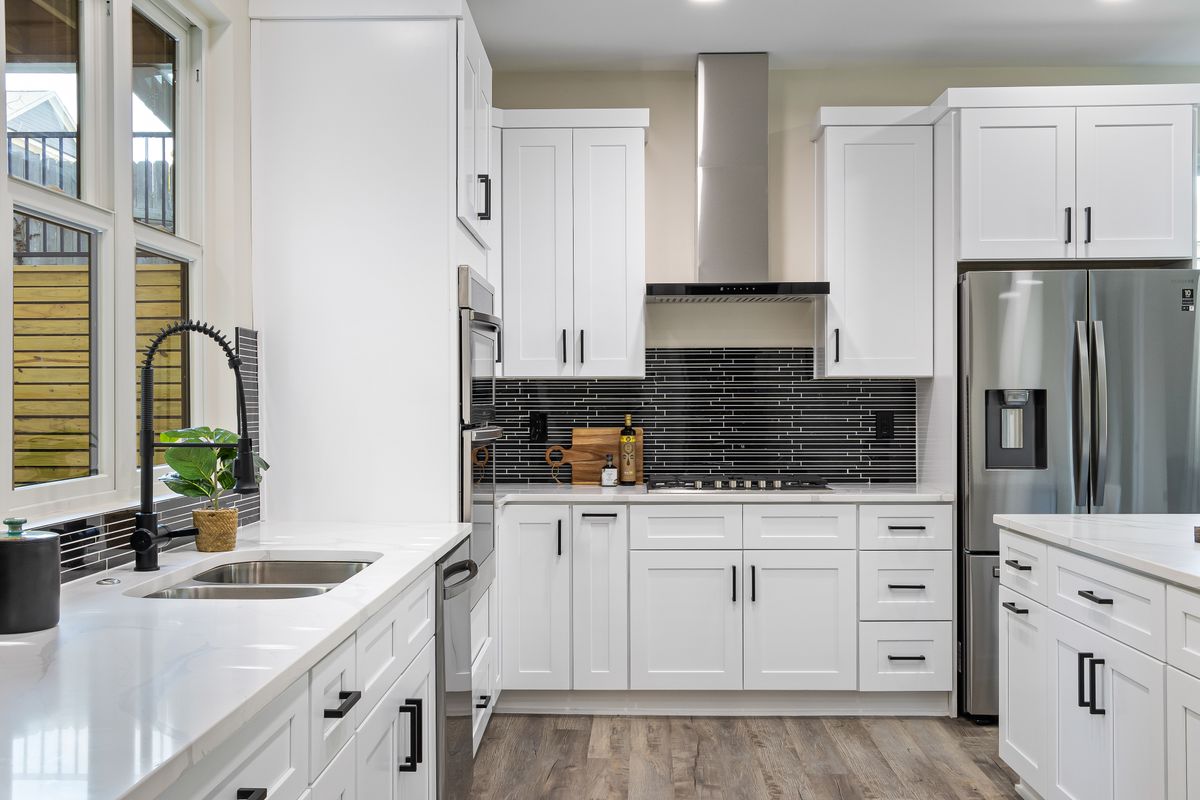 Kitchen renovation reference: white cabinetry and timber flooring (stock placeholder)