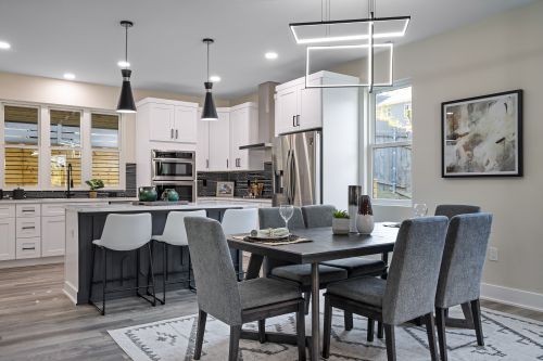 Free Elegant modern kitchen and dining area with sleek furniture and lighting. Stock Photo