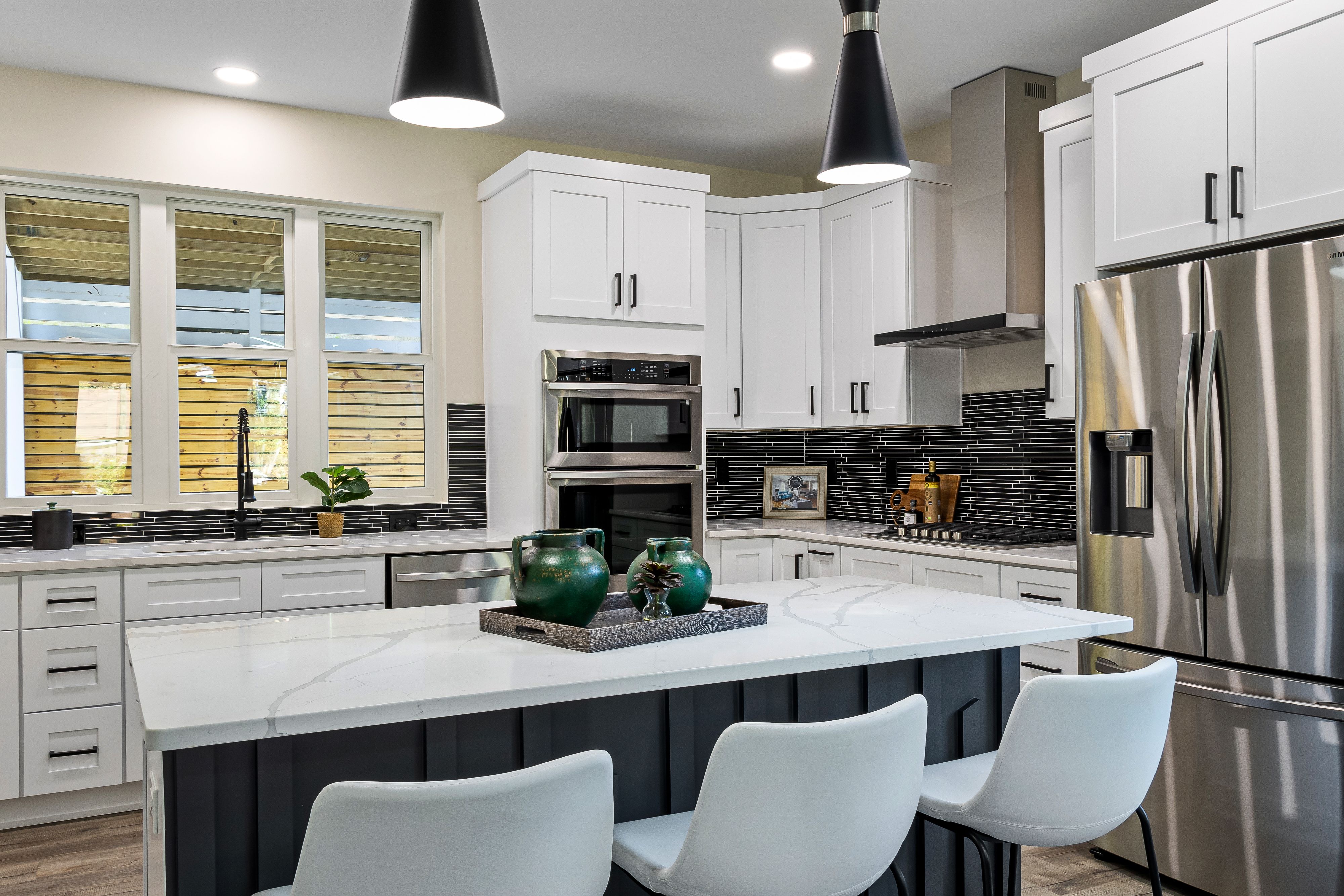 Küchensanierung – Sleek modern kitchen with a marble island, stainless steel appliances, and stylish decor.