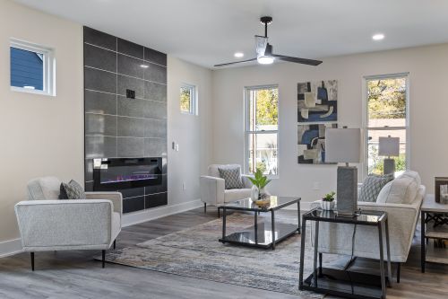 Free Stylish contemporary living room featuring a sleek fireplace, elegant furnishings, and natural light. Stock Photo