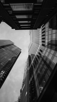 Dramatic view of modern skyscrapers in London's downtown district, captured in black and white.