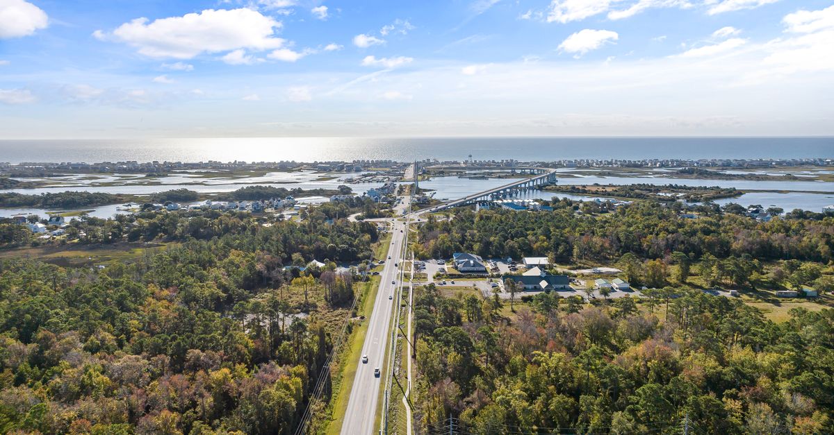 Drone shot capturing a scenic aerial view of a highway and bridge in Holly Ridge, NC.