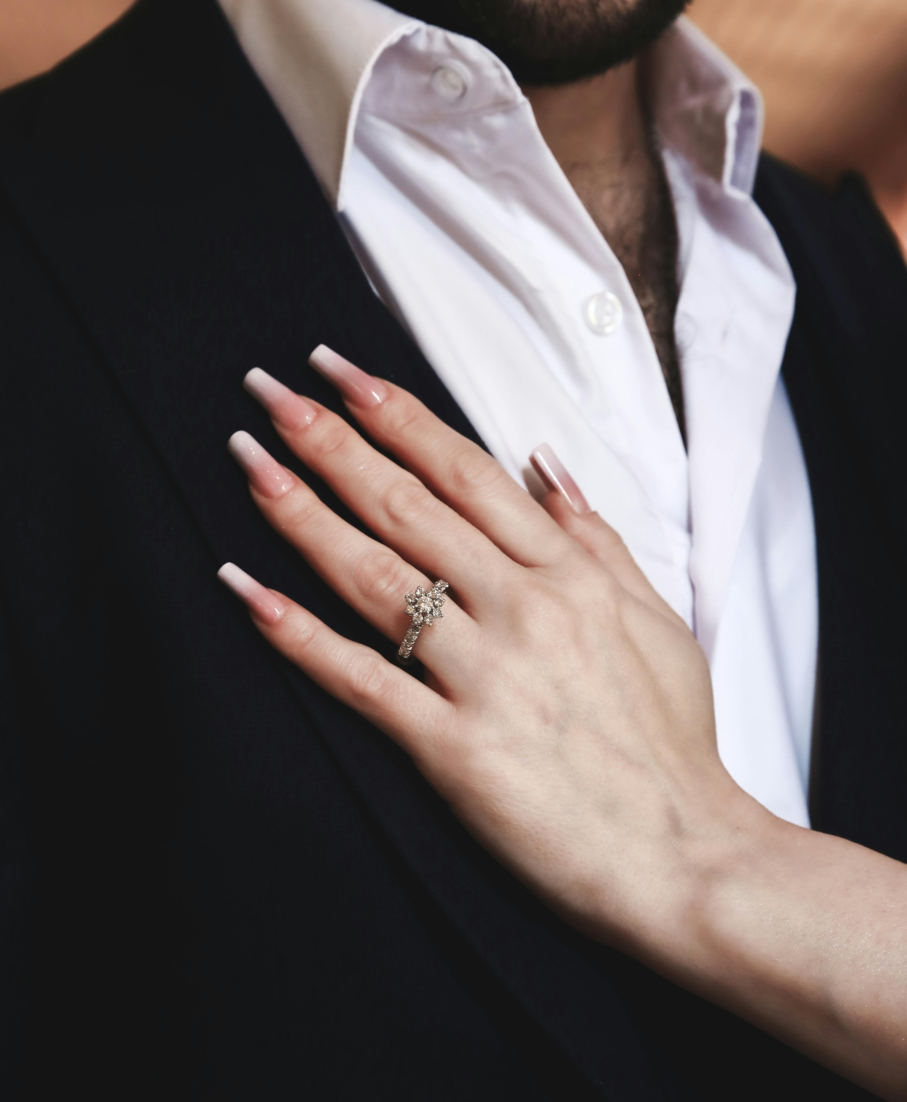 free photo of engagement ring on a womans hand resting on a man chest