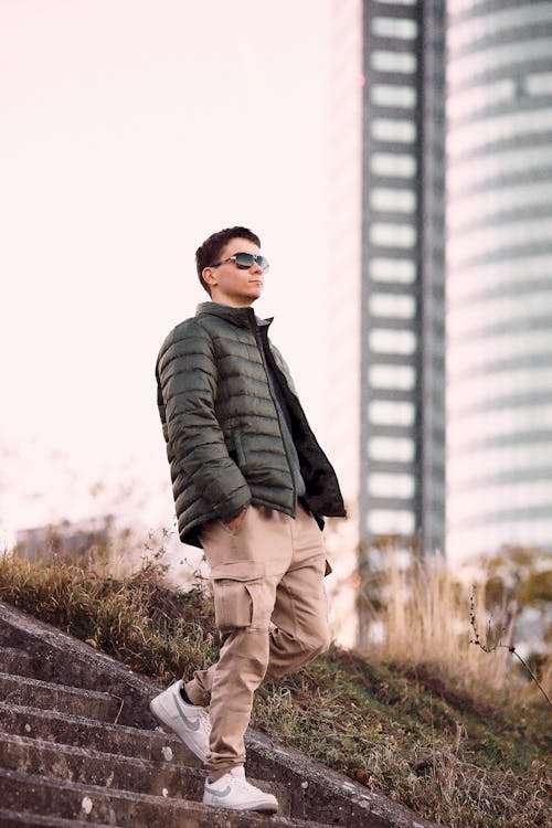 Young Man in a Casual Trendy Outfit Walking Down Steps in City 