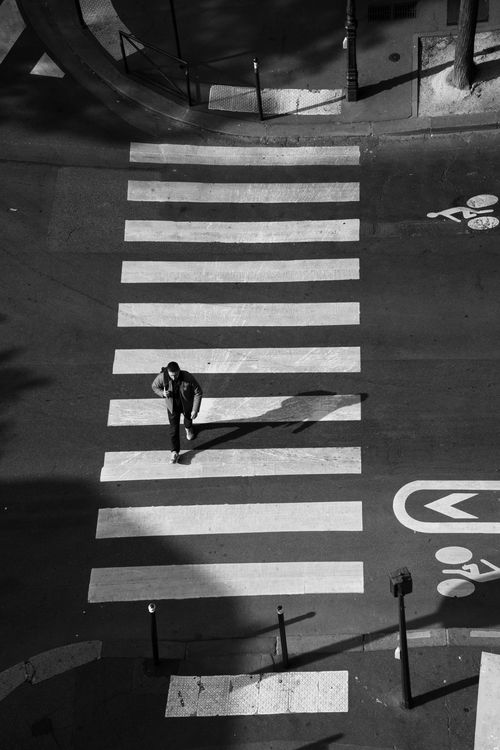 Free A man crosses a city street on a zebra crossing in an urban setting. Stock Photo