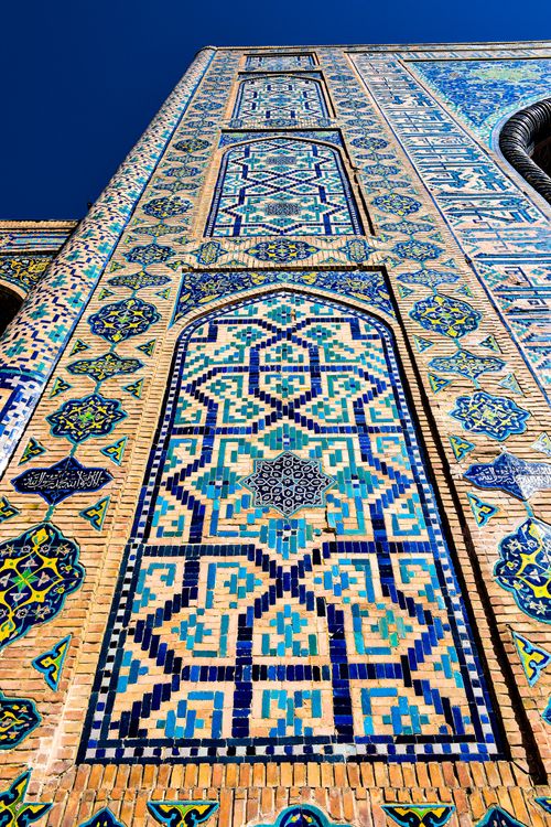 Free Vertical shot of intricate mosaic patterns on a historic Islamic architectural facade, showcasing vibrant colors. Stock Photo