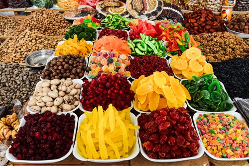 Free Colorful assortment of dried fruits and nuts on display at a market stall, showcasing a variety of textures and colors. Stock Photo