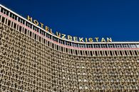 Low angle shot of Hotel Uzbekistan facade against a clear blue sky.