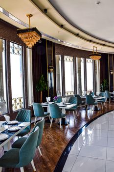 Sophisticated dining area featuring plush seating, chandeliers, and large windows.